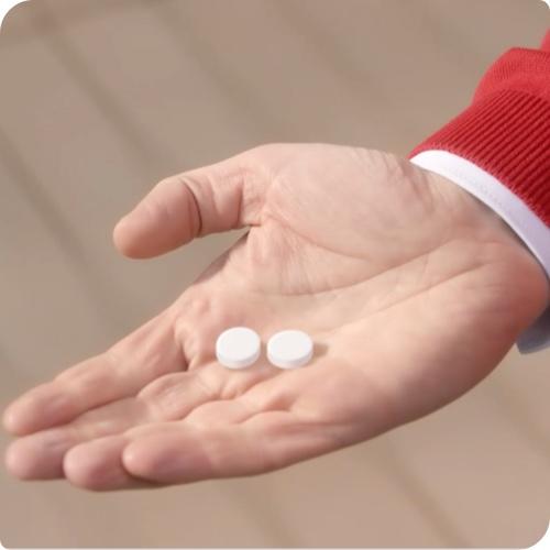 Person halt zwei Tabletten in der Hand